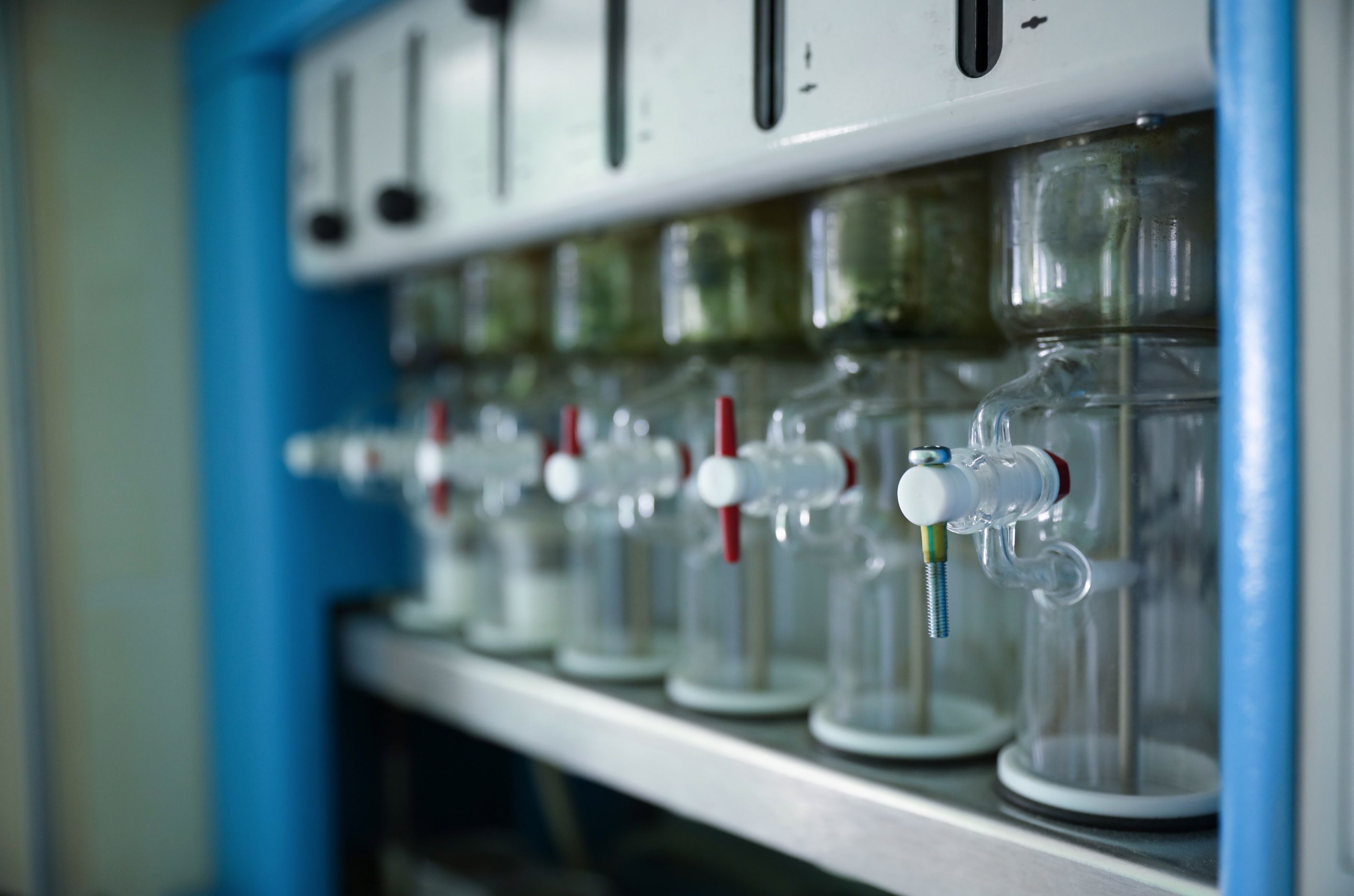 Szklane naczynia laboratoryjne i zawory – tło artykułu o rozpuszczalnikach